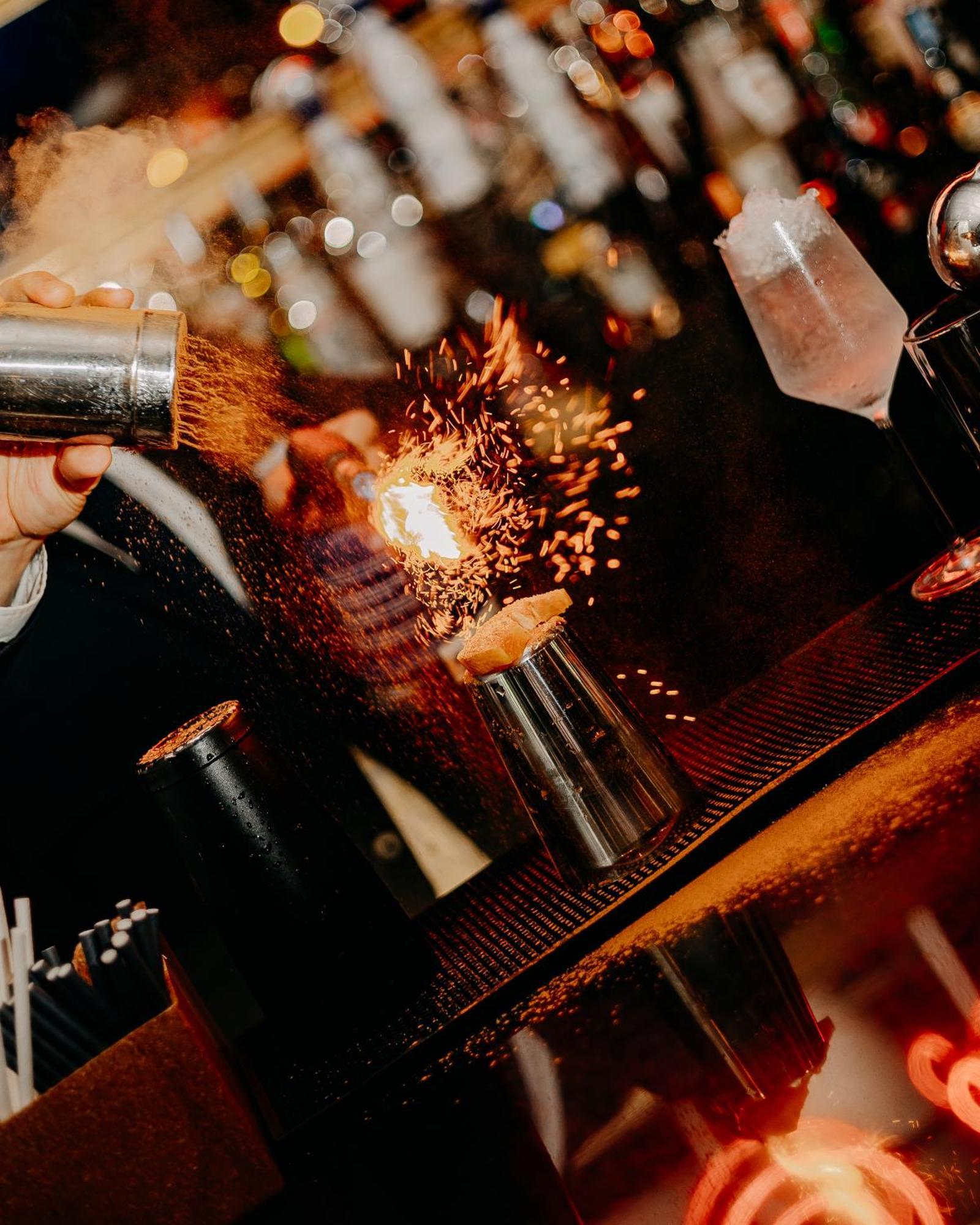 138 Liberdade Hotel ลิสบอน ภายนอก รูปภาพ A bartender using a cocktail gun to make a flaming shot